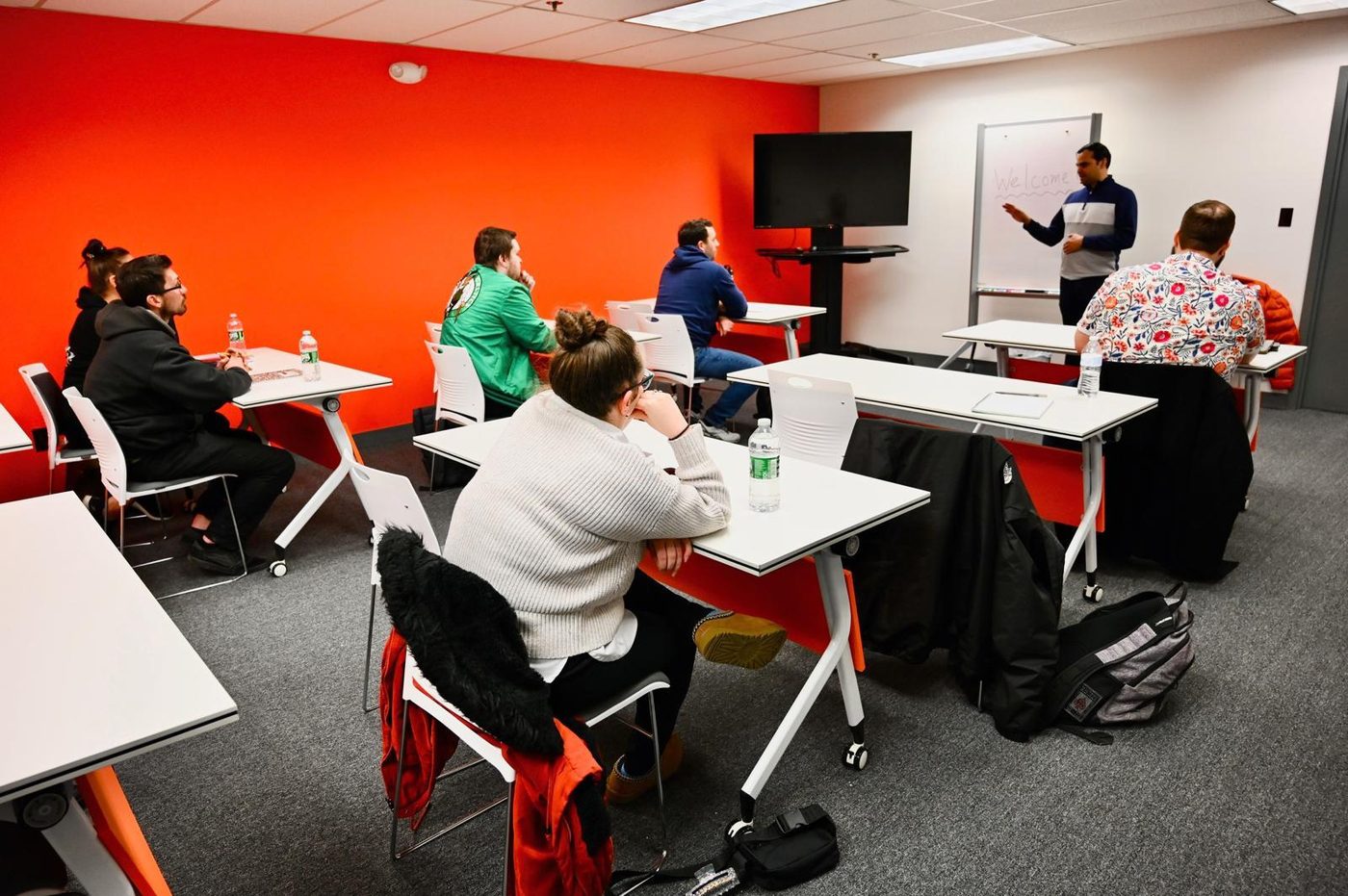 A Free Education Staffing class in session: learners at desks listening to an instructor at a whiteboard